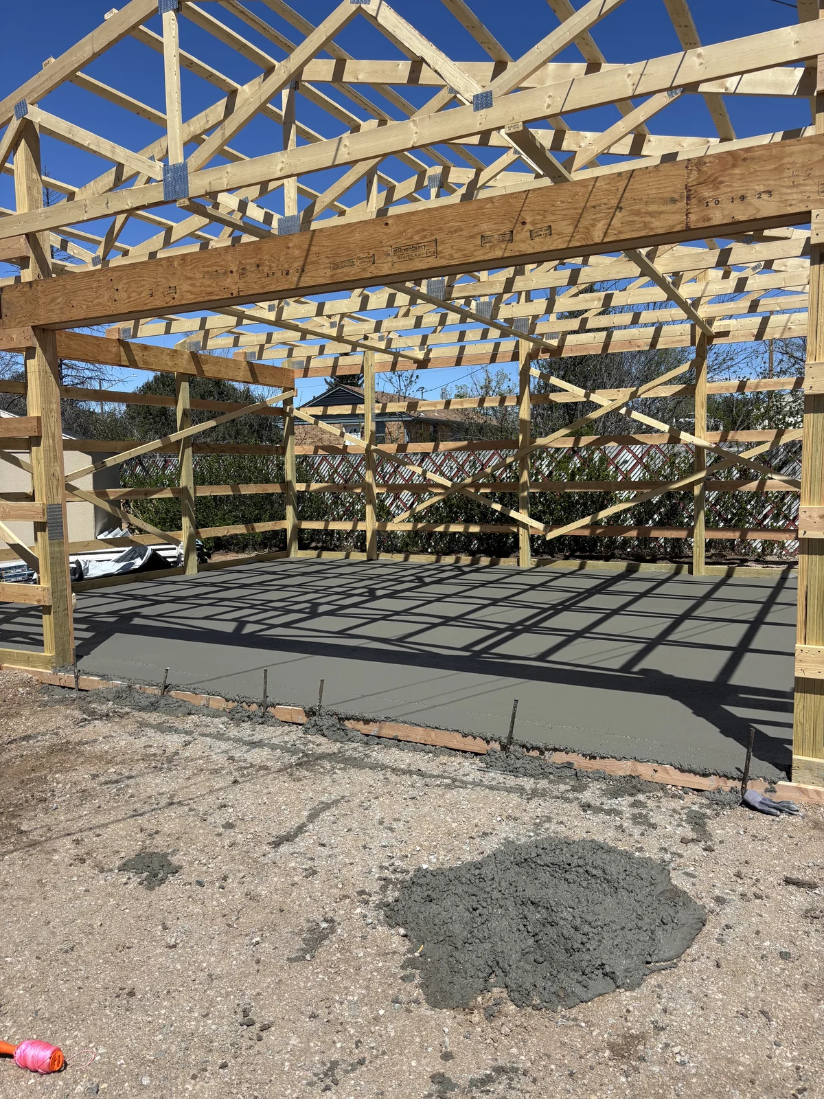 Pole barn framing over fresh concrete slab for barndominium build in southeast Wyoming